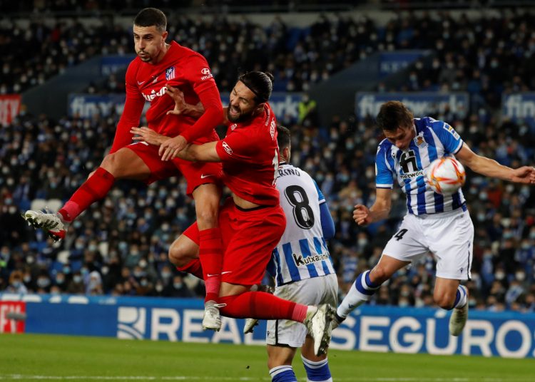 SAN SEBASTIÁN, 19/01/2022.- Los jugadores del Atlético de Madrid, Mario Hermoso (i) y el brasileño Felipe (2i), no consiguen despejar el balón ante el defensa francés de la Real Sociedad, Robin Le Normand (d), durante el encuentro correspondiente a los octavos de final de la Copa del Rey que disputan hoy miércoles en el Reale Arena de San Sebastián. EFE / Javier Etxezarreta.