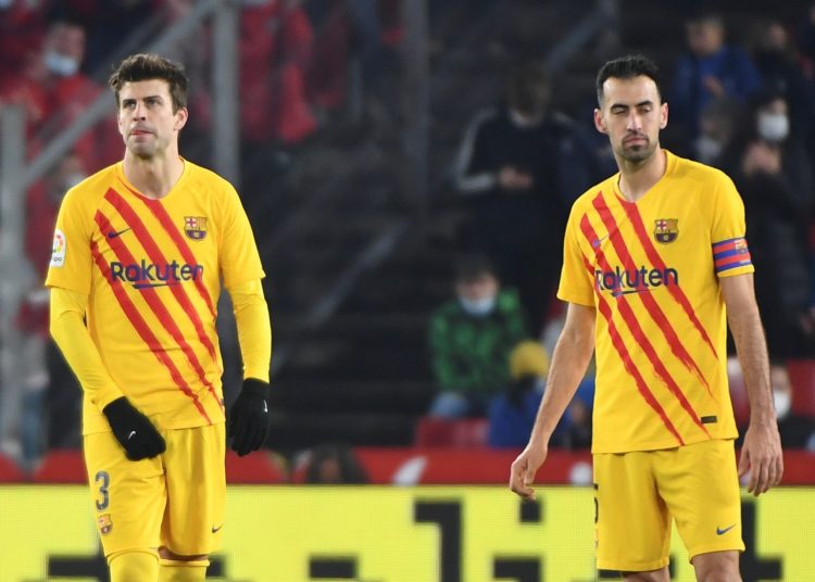 GRANADA, 8/01/2022.- Los jugadores del FC Barcelona, Gerard Piqué (i) y Sergi Busquets, tras encajar el gol que ha significado el empate a uno definitivo durante el encuentro correspondiente a la jornada 20 de primera división que han disputado hoy sábado frente al Granada en el estadio Nuevo los Cármenes de Granada. EFE / Miguel Ángel Molina.