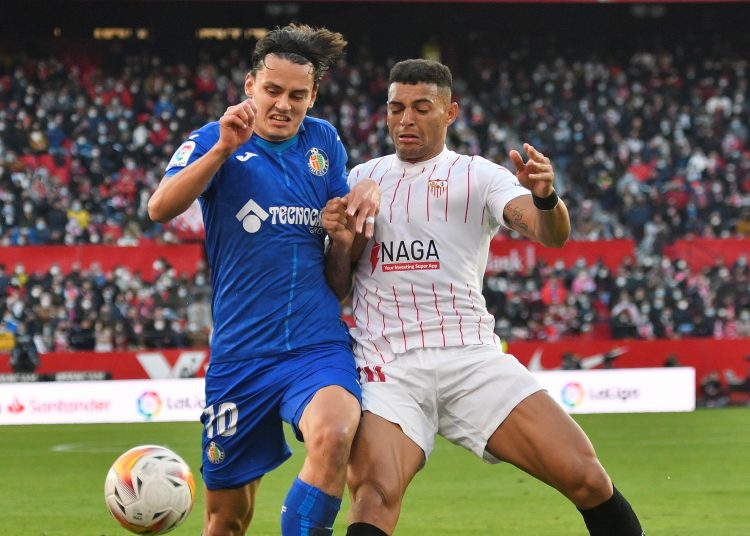 SEVILLA. 09/01/2022. - El delantero turco del Getafe, Enes Unal (i) pelea un balón con el defensa brasileño del Sevilla, Diego Carlos, durante el partido de la vigésima jornada de la Liga Santander que se disputa esta tarde en el estadio Ramón Sánchez Pizjúan de Sevilla. EFE/ Raúl Caro.