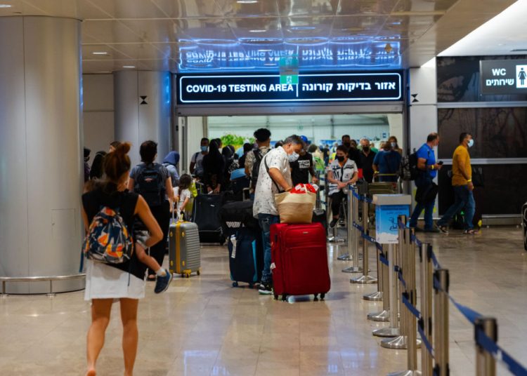 Travellers arriving at the Ben Gurion International Airport in Israel, stand in line to get a Covid19 check upon arrival. July 01, 2021. Photo by Nati Shohat/FLASH90 *** Local Caption *** קורונה
בדיקה
בן גוריון
שדה תעופה