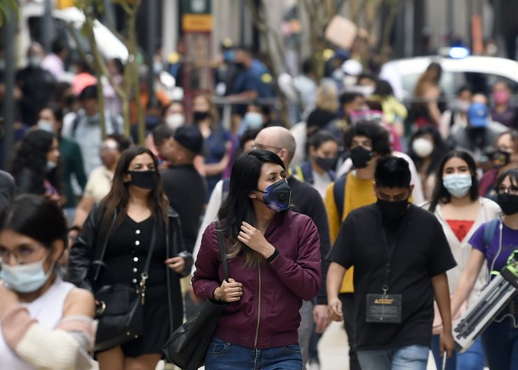 People walk in downtown in Mexico City on December 16, 2020, amid the COVID-19 pandemic. (Photo by ALFREDO ESTRELLA / AE / AFP)