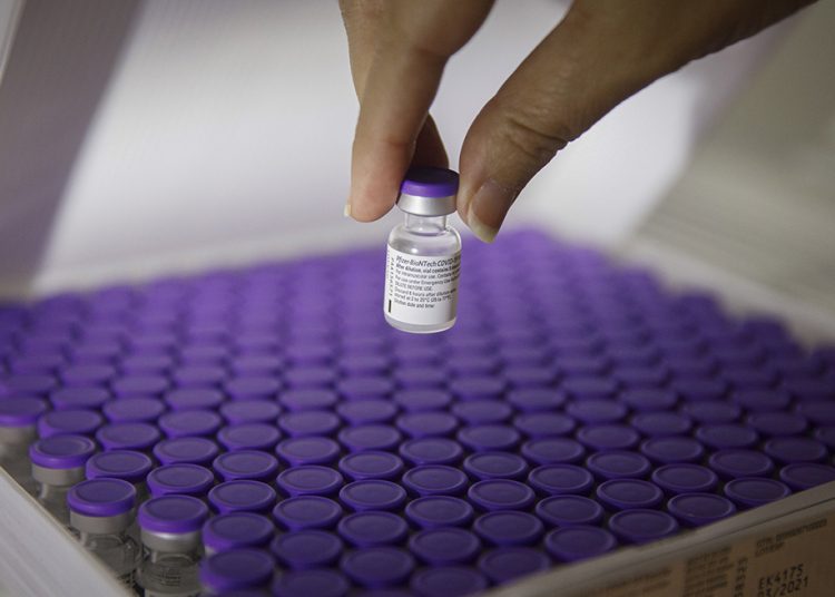 A nurse handles a vial of the the Pfizer-BioNTech Covid-19 vaccine in a refrigerator at the Wolfson medical center in Holon, Israel, on Saturday, Dec. 19, 2020. Israelis returning from the U.K., Denmark, and South Africa will be sent to isolation in government-run quarantine sites to help prevent a mutant strain of coronavirus from entering the country. Photographer: Kobi Wolf/Bloomberg via Getty Images