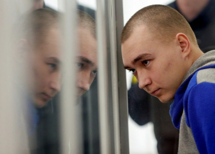 Russian soldier Vadim Shishimarin, 21, suspected of violations of the laws and norms of war, sits inside a cage during a court hearing, amid Russia's invasion of Ukraine, in Kyiv, Ukraine May 23, 2022. REUTERS/Viacheslav Ratynskyi
