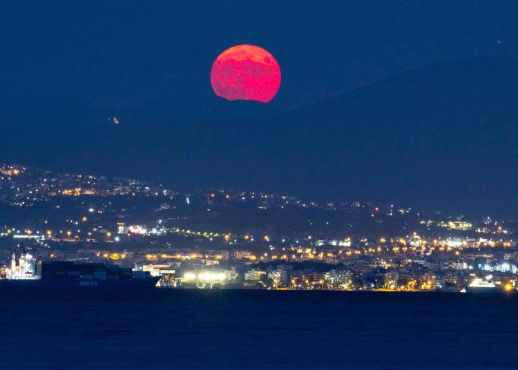 The August Sturgeon full moon rises behind the Hortiatis mountain and Thessaloniki city over the sea, skywatchers call it Blue Moon. The lunar moonlight is reflected on the water surface while it rises in warm red color near Kalochori town with the famous Lagoon and Axios Delta National Park.  The country offers free cultural events at sites, a tradition for Greece with Museums Across the country open at night while a number of free cultural events will take place on August 22, at Greece's archaeological sites and museums to mark the full moon celebrations, earth's natural satellite and the beginning of the summer ending. Kalohori, Thessaloniki, Greece on August 22, 2021 (Photo by Nicolas Economou/NurPhoto)
