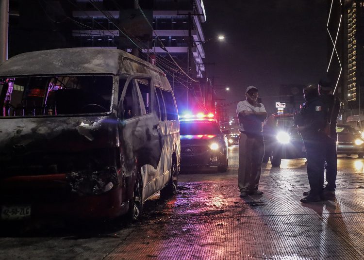 MEX1189. TIJUANA (MÉXICO), 13/08/2022.- Agentes de policía prestan guardia en la zona donde fue incendiado un vehículo, el 12 de agosto de 2022, en la ciudad de Tijuana, estado de Baja California (México). Autoridades de gobierno y de seguridad pública del estado mexicano de Baja California adjudicaron este sábado al Cártel Jalisco Nueva Generación los hechos de la jornada violenta que se vivió la tarde-noche del viernes y que dejó un total de 28 vehículos incendiados en cinco de los siete municipios del estado. EFE/ Joebeth Terriquez