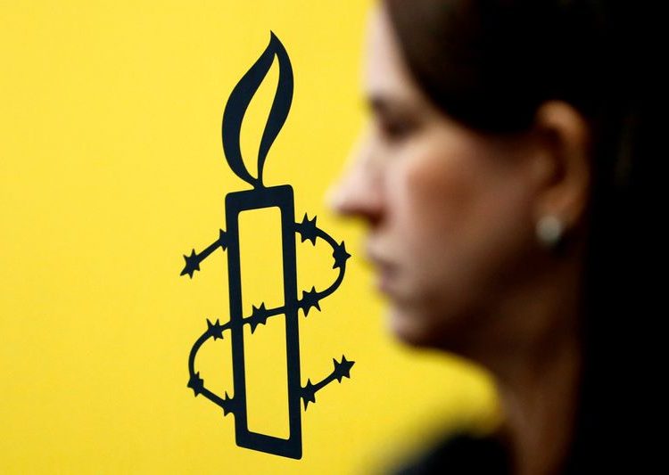 Imagen de archivo referencial del logo de Amnistía Internacional junto a la directora de Mujeres En Linea, Luisa Kislinger, durante una conferencia de prensa para anunciar los resultados de una investigación sobre abusos a los derechos humanos cometidos en Venezuela durante las protestas contra el presidente Nicolás Maduro en Caracas, Venezuela. 20 de febrero, 2019. REUTERS/Carlos Jass
