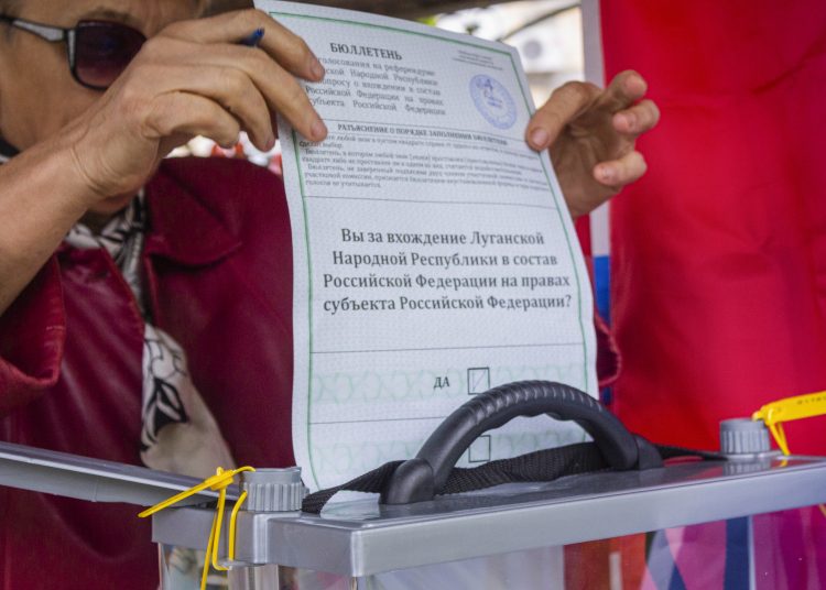 Luhansk (Ukraine), 24/09/2022.- A woman cast her ballot during voting in a referendum, at an outdoor polling station in Luhansk, eastern Ukraine, 24 September 2022. From 23 to 27 September, residents of the self-proclaimed Luhansk and Donetsk People's Republics as well as the Russian-controlled areas of the Kherson and Zaporizhzhia regions of Ukraine vote in a referendum to join the Russian Federation. On 24 February 2022 Russian troops entered the Ukrainian territory in what the Russian president declared a 'Special Military Operation', starting an armed conflict that has provoked destruction and a humanitarian crisis.  (Rusia, Ucrania) EFE/EPA/STRINGER