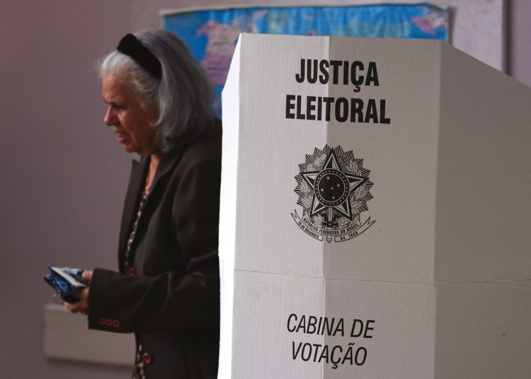 AME1534. SAO PAULO (BRASIL), 02/10/2022.- Una mujer sale de marcar su voto en una cabina de votación hoy, en el barrio San Mateus en Sao Paulo (Brasil). Los colegios electorales de Brasil abrieron este domingo para las elecciones presidenciales, legislativas y regionales, en las que el exmandatario brasileño Luiz Inácio Lula da Silva aparece como favorito en todas las encuestas frente al actual gobernante, Jair Bolsonaro. EFE/ Ettore Chiereguini