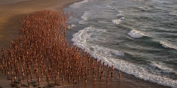 Personas se desnudan en playa australiana contra cáncer de piel