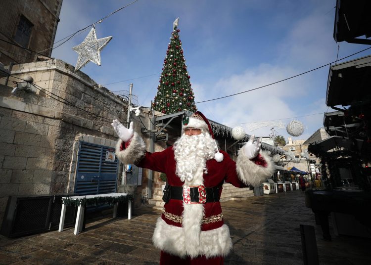 Jerusalem (Israel), 22/12/2022.- Issa Kassissieh, dressed as Santa Claus, greets people ahead of Christmas celebrations in Jerusalem's old city, 22 December 2022. (Estados Unidos, Jerusalén) EFE/EPA/ATEF SAFADI