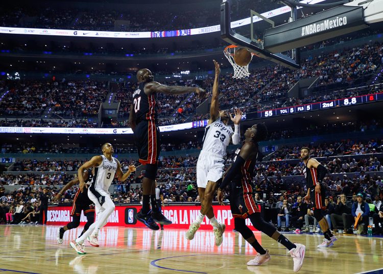 MEX2664. CIUDAD DE MÉXICO (MÉXICO), 17/12/2022.- Tre Jones de San Antonio Spurs lanza hoy el balón ante la marca de Víctor Oladipo (d) y Dewayne Dedmon (i) de los Miami Heat , durante un juego de la temporada 2022-2023 de la NBA en la Arena Ciudad de México (México). EFE/ Isaac Esquivel