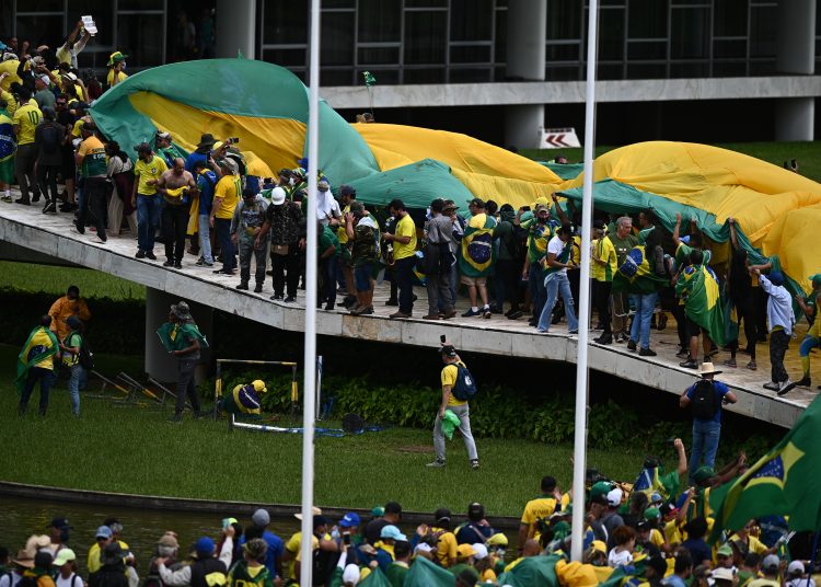 AME4954. BRASILIA (BRASIL), 08/01/2023.- Manifestantes contra los resultados electorales y el gobierno del recién posesionado presidente Lula da Silva invaden el Congreso Nacional, el Supremo Tribunal Federal y el Palacio del Planalto, sede de la Presidencia de la República, hoy, en Brasilia (Brasil). Seguidores del expresidente brasileño Jair Bolsonaro invadieron este domingo el Palacio de Planalto, sede del Ejecutivo, y la Corte Suprema, después de haber irrumpido antes en el Congreso Nacional en actos golpistas contra el presidente Luiz Inácio Lula da Silva. Los ventanales de la sede del poder Judicial y del Congreso Nacional fueron rotos por los manifestantes, que ya ocupan los edificios de los tres poderes en el país.EFE/ Andre Borges