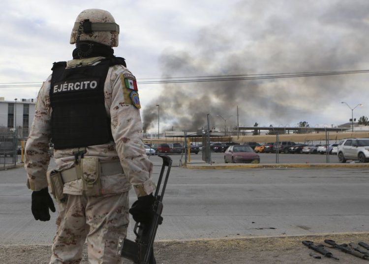 A Mexican soldiers stands guard outside a state prison in Ciudad Juarez, Mexico, Sunday Jan 1, 2023. Mexican soldiers and state police regained control of a state prison in Ciudad Juarez across the border from El Paso, Texas after violence broke out early Sunday, according to state officials. (AP Photo/Christian Chavez)