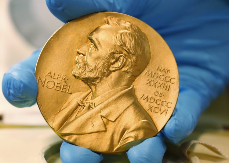 FILE- A national library employee shows a gold Nobel Prize medal in Bogota, Colombia Friday, April 17, 2015. (AP Photo/Fernando Vergara, file)