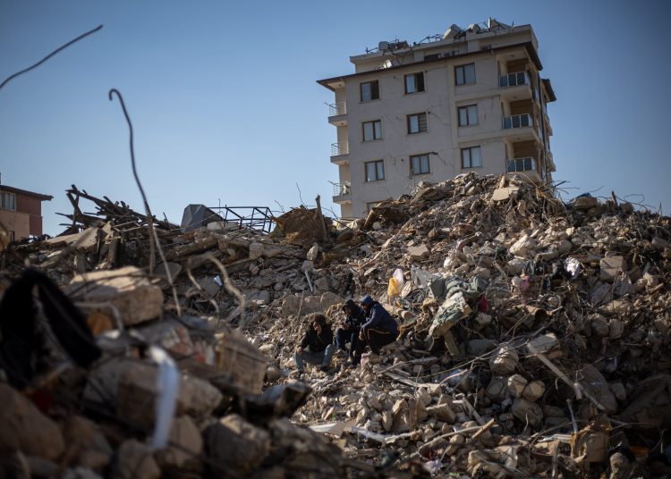 Hatay (antakya) (Turkey), 14/02/2023.- People sit on the rubble of a collapsed building in the aftermath of a powerful earthquake, in Hatay city, Turkey, 14 February 2023. More than 37,000 people died and thousands more were injured after two major earthquakes struck southern Turkey and northern Syria on 06 February. Authorities fear the death toll will keep climbing as rescuers look for survivors across the region. (Terremoto/sismo, Siria, Turquía, Estados Unidos) EFE/EPA/MARTIN DIVISEK
