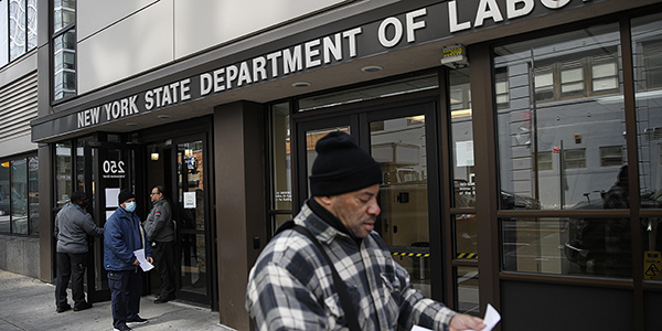 FILE - In this March 18, 2020 file photo, visitors to the Department of Labor are turned away at the door by personnel due to closures over coronavirus concerns in New York. A record-high number of people applied for unemployment benefits last week as layoffs engulfed the United States in the face of a near-total economic shutdown caused by the coronavirus. The surge in weekly applications for benefits far exceeded the previous record set in 1982. (AP Photo/John Minchillo, File)