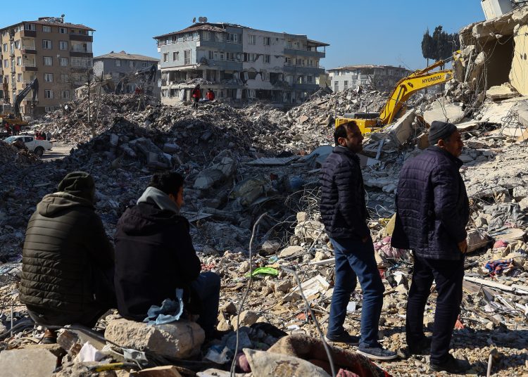 Hatay (Turkey), 15/02/2023.- People stand on debris while rescuers work at the site of collapsed buildings after a powerful earthquake, in Hatay, Turkey, 15 February 2023. More than 41,000 people died and thousands more were injured after two major earthquakes struck southern Turkey and northern Syria on 06 February. Authorities fear the death toll will keep climbing as rescuers look for survivors across the region. (Terremoto/sismo, Siria, Turquía, Estados Unidos) EFE/EPA/SEDAT SUNA