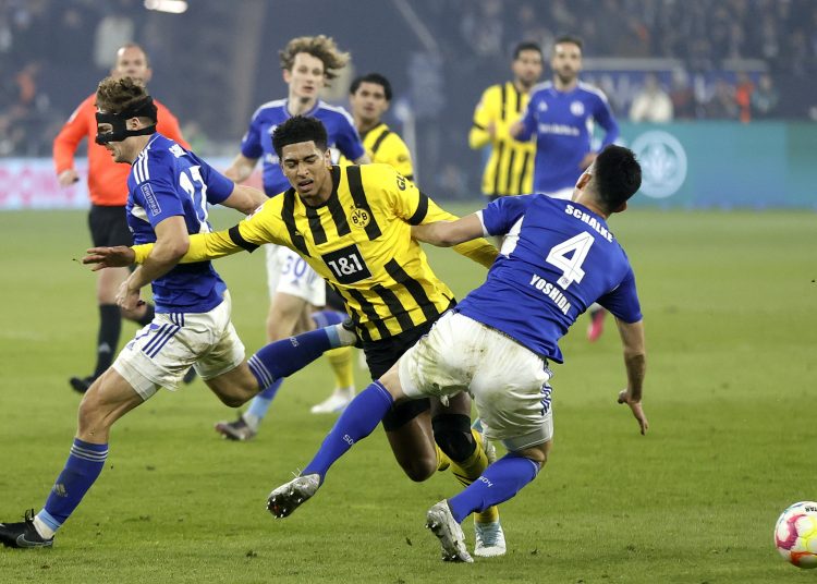 Gelsenkirchen (Germany), 11/03/2023.- Dortmund's Jude Bellingham (C) in action against Schalke's Cedric Brunner (L) and Maya Yoshida (R) during the German Bundesliga soccer match between FC Schalke 04 and Borussia Dortmund in Gelsenkirchen, Germany, 11 March 2023. (Alemania, Rusia) EFE/EPA/RONALD WITTEK CONDITIONS - ATTENTION: The DFL regulations prohibit any use of photographs as image sequences and/or quasi-video.