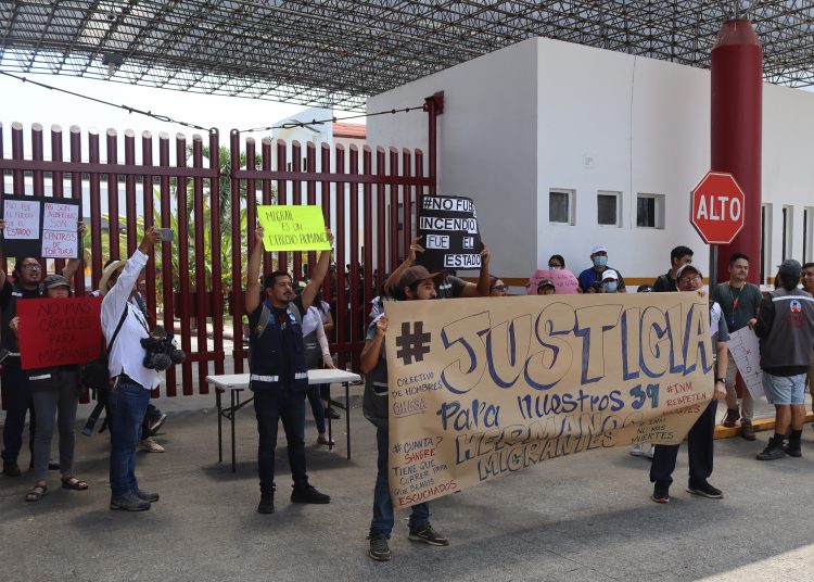 MEX820. TAPACHULA (MÉXICO), 29/03/2023.- Migrantes y activistas de diferentes organizaciones protestan afuera de una estación migratoria, hoy, en el municipio de Tapachula, en Chiapas (México).  Migrantes y activistas protestaron este miércoles en Chiapas, estado de la frontera sur de México, tras el incendio que dejó 39 muertos en una estación del Instituto Nacional de Migración (INM) en Ciudad Juárez, en el límite con Estados Unidos. Los manifestantes cuestionaron el discurso del Gobierno de México tras el incidente, del que han responsabilizado a los migrantes y han afirmado que fue en un "albergue". EFE/Juan Manuel Blanco