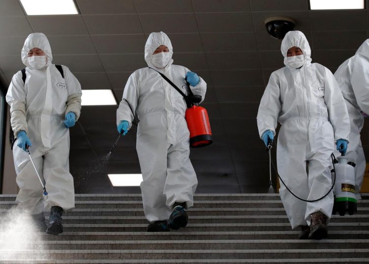 Workers wearing protective gears disinfect as a precaution against the new coronavirus at the subway station in Seoul, South Korea, Friday, March 13, 2020. For most people, the new coronavirus causes only mild or moderate symptoms, such as fever and cough. For some, especially older adults and people with existing health problems, it can cause more severe illness, including pneumonia. (AP Photo/Lee Jin-man)