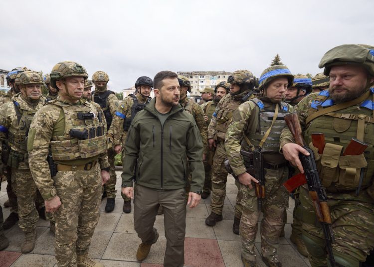 In this photo provided by the Ukrainian Presidential Press Office, Ukrainian President Volodymyr Zelenskyy, center, is surrounded by soldiers during his visit in Izium, Kharkiv region, Ukraine, Wednesday, Sept. 14, 2022. Ukrainian troops piled pressure on retreating Russian forces Tuesday, pressing deeper into occupied territory and sending more Kremlin troops fleeing ahead of the counteroffensive that has inflicted a stunning blow on Moscow's military prestige.(Ukrainian Presidential Press Office via AP)