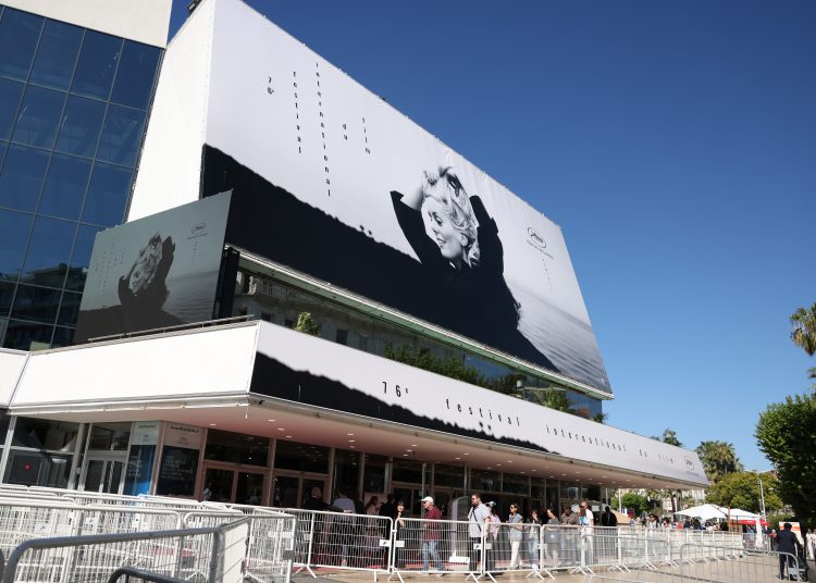 Cannes (France), 16/05/2022.- Pedestrians walk past the giant festival poster featuring a young Catherine Deneuve prior to the Opening Ceremony of the 76th annual Cannes Film Festival, in Cannes, France, 16 May 2023. The festival runs from 16 to 27 May. (Cine, Francia) EFE/EPA/Mohammed Badra
