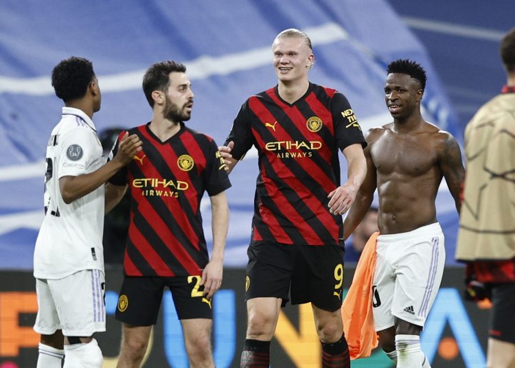 MADRID, 09/05/2023.- Los jugadores brasileños del Real Madrid, Vinicius Jr. (d) y Rodrygo (i), se saludan con el noruego del Manchester City, Erling Haaland y el portugués Bernardo Silva, a la finalización del encuentro correspondiente a la ida de las semifinales de la Liga de Campeones que han disputado hoy martes en el estadio Santiago Bernabéu, en Madrid. EFE / Rodrigo Jiménez.