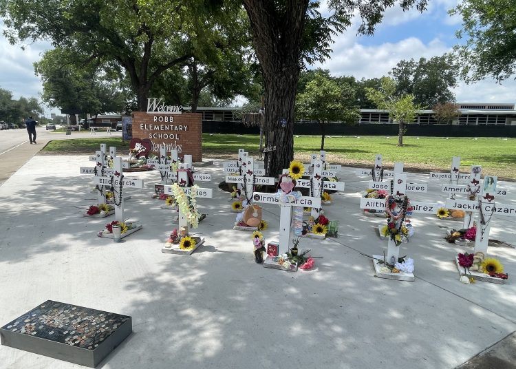 USA7416. UVALDE (TX, EEUU), 23/05/2023.- Fotografía que muestra las cruces blancas que llevan los nombres de las víctimas de la matanza de la Escuela Primaria Robb instaladas en la entrada del instituto en Uvalde, Texas (EE.UU.). Cruces decoradas con flores, juguetes y fotos infantiles decoloradas por el sol, un colegio vallado esperando a ser demolido, y una comunidad dividida entre quienes piden más control a las armas y quienes no aceptan restricciones. Uvalde recuerda, un año después, la matanza que cambió a todos, pero que no ha cambiado nada. EFE/Paula Escalada Medrano