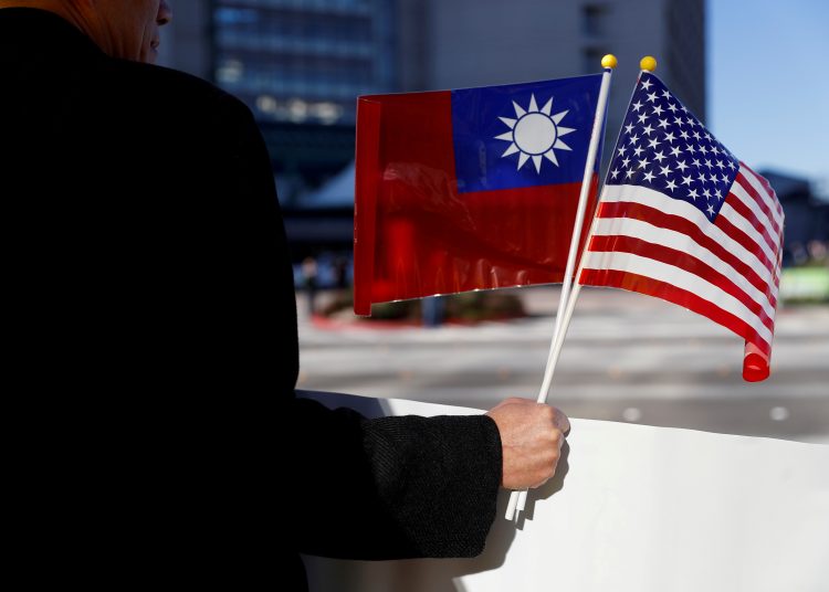 FILE PHOTO: A man holds flags of Taiwan and the United States in support of Taiwanese President Tsai Ing-wen during an stop-over after her visit to Latin America in Burlingame, California, U.S., January 14, 2017. REUTERS/Stephen Lam/File Photo