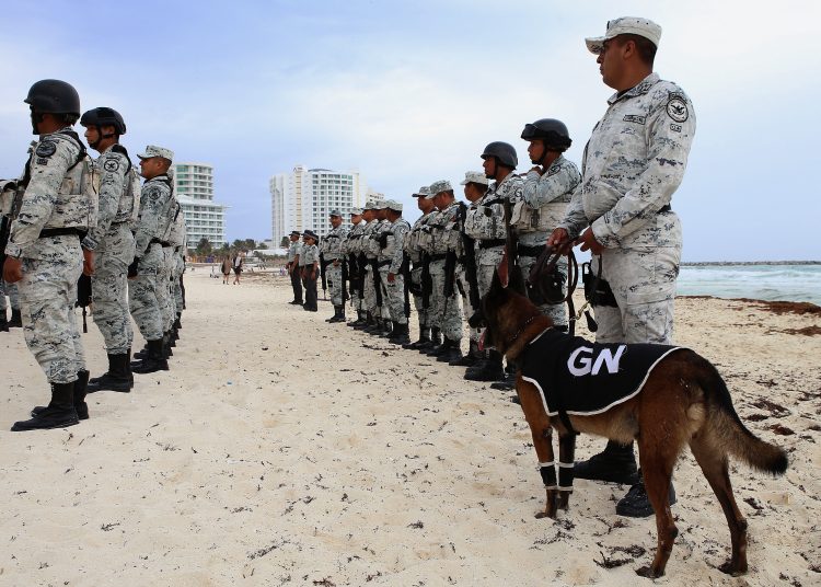 MEX8641. CANCÚN (MÉXICO), 25/06/2023.- Integrantes de la Guardia Nacional vigilan una playa el 24 de junio de 2023, en el balneario de Cancún, Quintana Roo (México). México inició este domingo el despliegue de elementos de la Guardia Nacional en Cancún, en el sureste del país, para reforzar la seguridad de su principal destino turístico del país ante una ola de violencia relacionada con la venta de droga. EFE/Lourdes Cruz