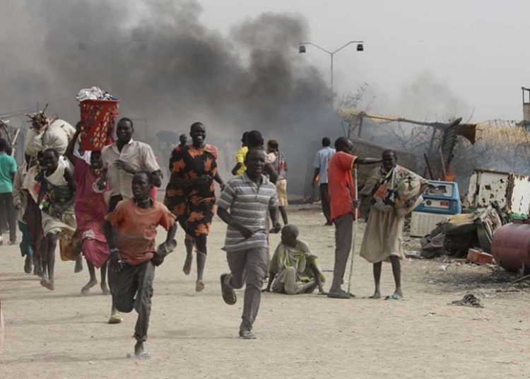TOPSHOT - South Sudanese civilians flee fighting in an United Nations base in the northeastern town of Malakal on February 18, 2016, where gunmen opened fire on civilians sheltering inside killing at least five people.

Gunfire broke out in the base in Malakal in the northeast Upper Nile region on February 17, 2016 night, with clashes continuing on Thursday morning that left large plumes of smoke rising from burning tents in the camp which houses over 47,000 civilians.
 / AFP / Justin LYNCH        (Photo credit should read JUSTIN LYNCH/AFP/Getty Images)