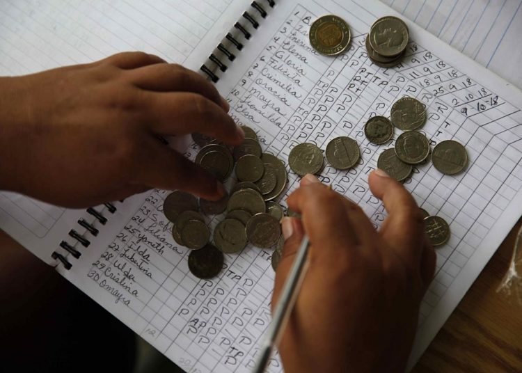 PANAMÁ INDÍGENAS:ACOMPAÑA CRÓNICA: PANAMÁ INDÍGENAS - PA02. IPETÍ (PANAMÁ), 10/10/2018.- Fotografía del 9 de octubre de 2018, que muestra a mujeres mientras cuentan monedas para depositarlos en una caja rural, en la comunidad de Ipetí Emberá-Alto Bayano, en el distrito de Chepo (Panamá). Cuentas de ahorro, libretas navideñas e incluso préstamos, son parte del abanico de productos de una "caja rural" que lideran mujeres Emberá en el corazón de la selva panameña, que se han propuesto convertirlo en un banco solo para los indígenas para acabar la marginación que sufren. EFE/Bienvenido Velasco[ACOMPAÑA CRÓNICA: PANAMÁ INDÍGENAS]