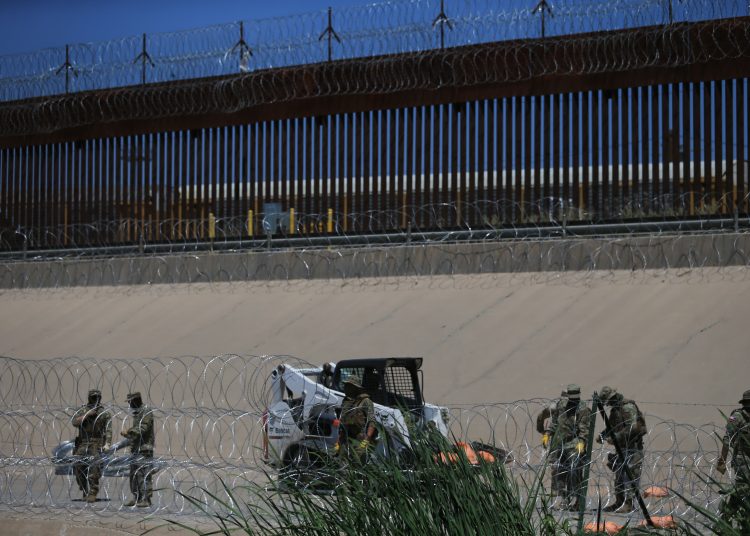 MEX1385. CIUDAD JUÁREZ (MÉXICO), 30/07/2023.- Miembros de la Guardia Nacional de Texas refuerzan la frontera norte con púas aceradas debajo del Puente Internacional Reforma, el 28 de julio de 2023 en Ciudad Juárez, Chihuahua (México). Integrantes de la Guardia Nacional de Estados Unidos reforzaron este viernes las barricadas de alambre de navaja y de malla en la frontera Juárez-El Paso a pesar de una demanda del Gobierno Federal estadounidense para retirar esta barrera que migrantes tildaron de "inhumana" y ambientalistas dijeron que es un riesgo para el ecosistema. EFE/Luis Torres