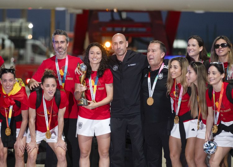 MADRID, 21/08/2023.- Las jugadoras de la selección española de fútbol, nueva campeona del Mundo, acompañadas por su entrenador Jorge Vilda y por el presidente de RFEF Luis Rubiales, posan con el trofeo a su llegada al aeropuerto de Barajas, este lunes en Madrid. EFE/FERNANDO VILLAR