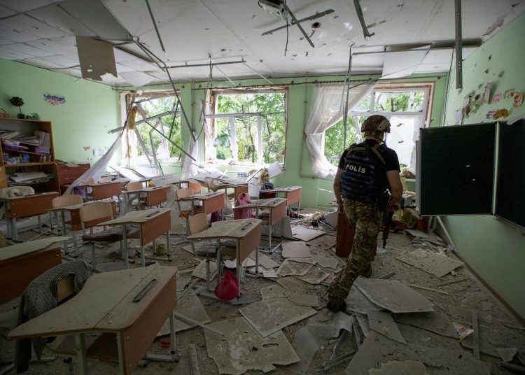 A police officer checks a school during an evacuation of local residents between shelling, amid Russia's attack on Ukraine, in the town of Marinka, in Donetsk region, Ukraine May 31, 2022. Picture taken May 31, 2022.  REUTERS/Anna Kudriavtseva