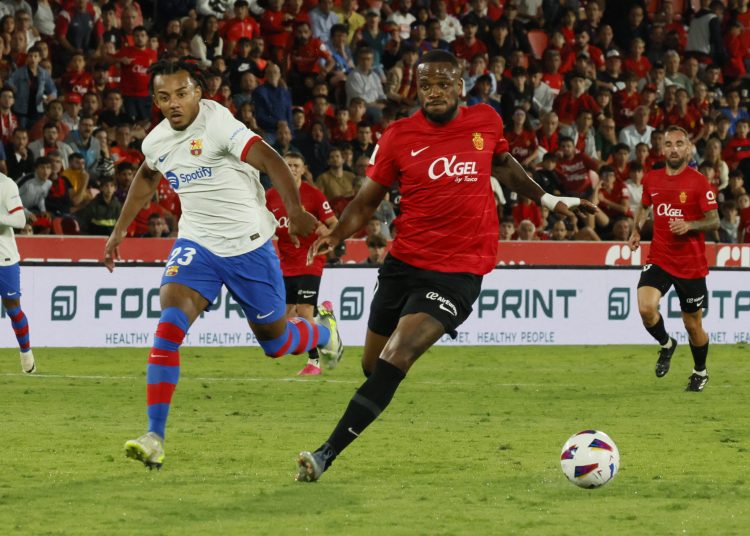 PALMA DE MALLORCA (ISLAS BALEARES), 26/09/2023.- El francés Jules Koundé (i), del FC Barcelona, persigue al canadiense Cyle Larin (d), del Mallorca, durante el partido de la séptima jornada de LaLiga entre el RCD Mallorca y el FC Barcelona, hoy martes en Son Moix, Palma de Mallorca. EFE/Cati Cladera