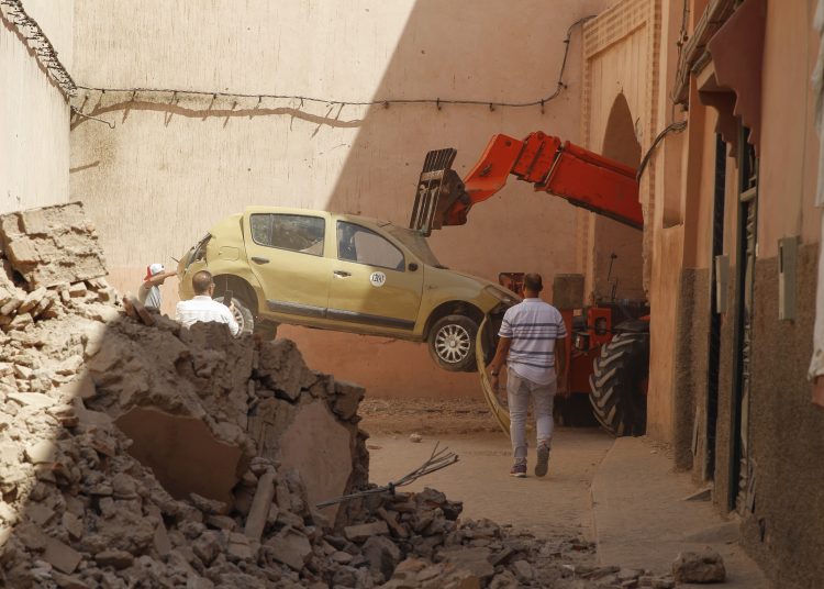 MARRAKECH (MARRUECOS), 11/09/2023.- Un grupo de personas trata de mover un coche este lunes, entre los escombros de los edificios destruidos por el terremoto y las pequeñas calles de la judería de Marrakech (Marruecos). Las angostas calles de la "mellah" (judería) de Marrakech, un barrio pobre, de profusión de casas de adobe en las que viven cientos de marroquíes, están llenas de escombros. Sus paredes no resistieron el terremoto del pasado viernes y ahora sus habitantes se ven forzados a dormir en la calle. "Le ha tocado a la gente más humilde, aquí y en el Atlas". Abdelali Shouli, un veterano guía de Marrakech, resume así lo ocurrido en la "mellah", un barrio encajado en la medina (ciudad antigua) y de fisionomía diferente. EFE/ María Traspaderne