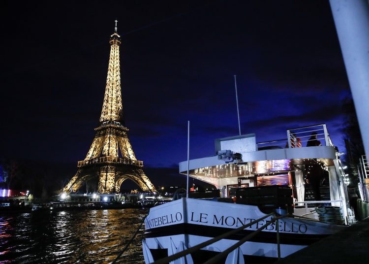 Paris (France), 24/12/2023.- A river boat is seen with the illuminated Eiffel Tower in the background during a Solidarity Christmas dinner organized by the non-profit association Secours Catholique on six barges on the banks of the Seine river, in Paris, France, 24 December 2023. The event, called 'Fraternoel' (Fraternal Christmas), is organized by Secours Catholique throughout France. More than 600 people in precarious circumstances from Ile-de-France are expected to attend the event. (Francia) EFE/EPA/TERESA SUAREZ