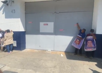 Normalistas de Ayotzinapa derriban puerta del Centro Federal de Arraigos