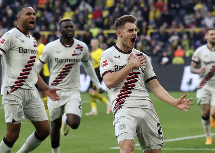 Dortmund (Germany), 21/04/2024.- Leverkusen's Josip Stanisic (R) celebrates with teammates after scoring the 1-1 equalizer during the German Bundesliga soccer match between Borussia Dortmund and Bayer 04 Leverkusen in Dortmund, Germany, 21 April 2024. (Alemania, Rusia) EFE/EPA/CHRISTOPHER NEUNDORF CONDITIONS - ATTENTION: The DFL regulations prohibit any use of photographs as image sequences and/or quasi-video.