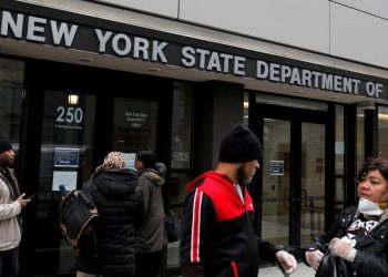 Personas caminando frente a oficina de empleo en Estados Unidos