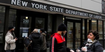 Personas caminando frente a oficina de empleo en Estados Unidos