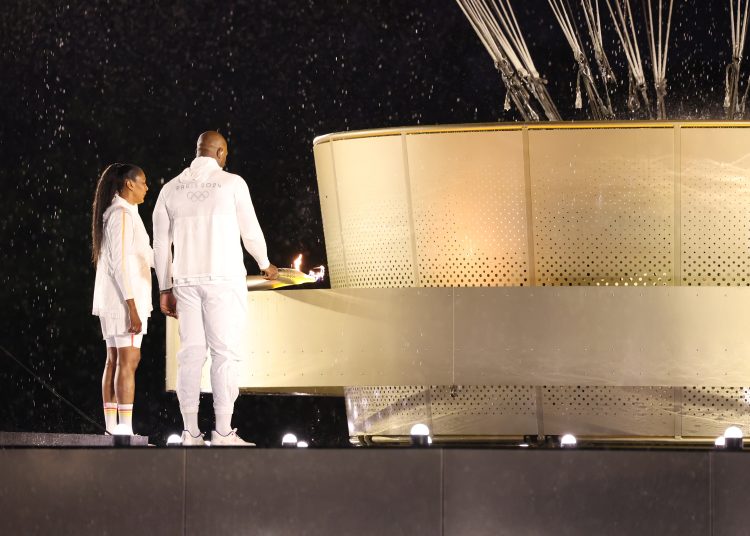 PARÍS (FRANCIA), 26/07/2024.- Los atletas galos Marie-Jose Perec (i) y Teddy Riner (d) encienden el pebetero durante la ceremonia de inauguración de los Juegos Olímpicos de París 2024, este viernes en la capital francesa. EFE/ Jan Woitas POOL