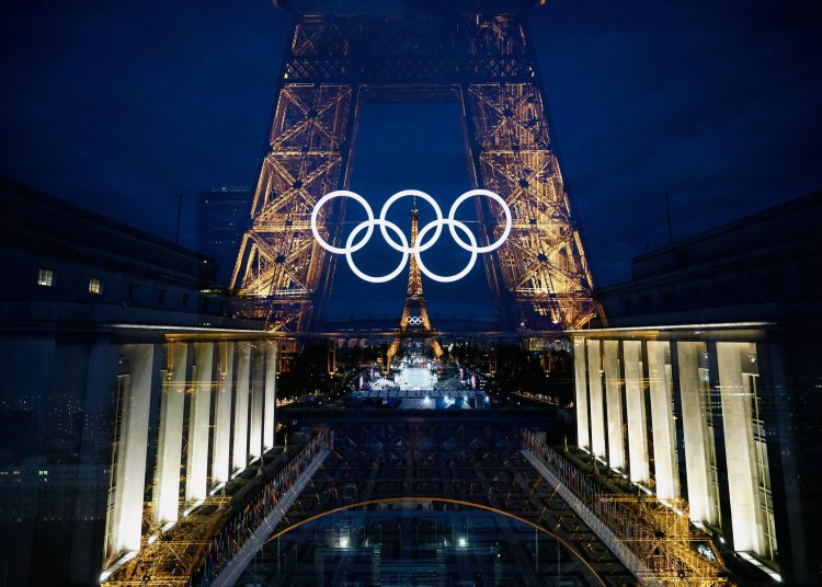 Paris (France), 22/07/2024.- An in-camera double exposure photo shows the Eiffel Tower, decorated with the illuminated Olympic rings in Paris, France, 22 July 2024. The opening ceremony of the Paris 2024 Olympic Games will begin with a nautical parade on the Seine and end on the protocol stage in front of the Eiffel Tower on 26 July. (Francia) EFE/EPA/ALEX PLAVEVSKI