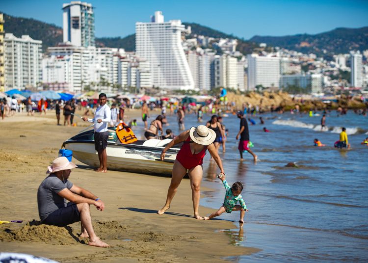 MEX8769. ACAPULCO (MÉXICO), 31/12/2024.- Turistas disfrutan en una playa del balneario de Acapulco este lunes, en el estado de Guerrero (México). El puerto mexicano de Acapulco cierra 2024 cierra con una recuperación de cerca del 65 % de sus alojamientos turísticos tras padecer dos de los huracanes más devastadores en la historia reciente de México en los últimos 14 meses, Otis en octubre de 2023 y John en septiembre pasado. EFE/ David Guzmán