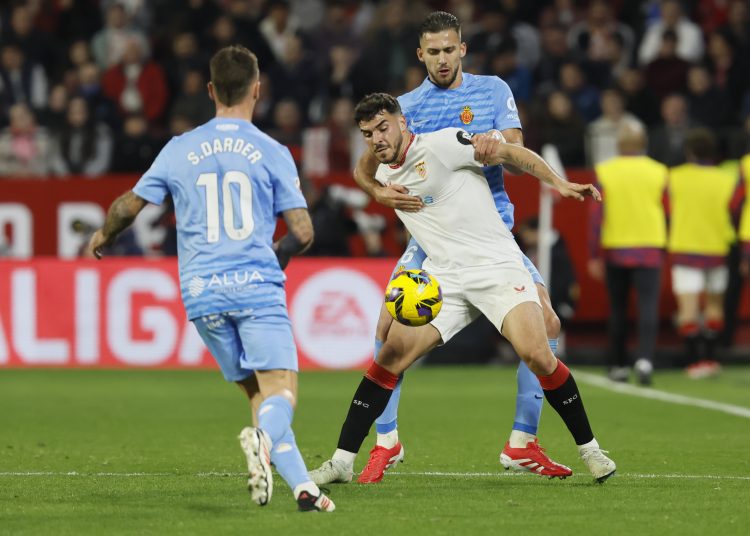 SEVILLA, 24/2/2025.- El delantero del Sevilla Isaac Romero (c) protege un balón entre José Manuel Copete (d) y Sergi Darder, ambos del Mallorca, durante el partido de LaLiga de fútbol que Sevilla FC y RCD Mallorca disputan este lunes en el estadio Ramón Sánchez-Pizjuán. EFE/José Manuel Vidal