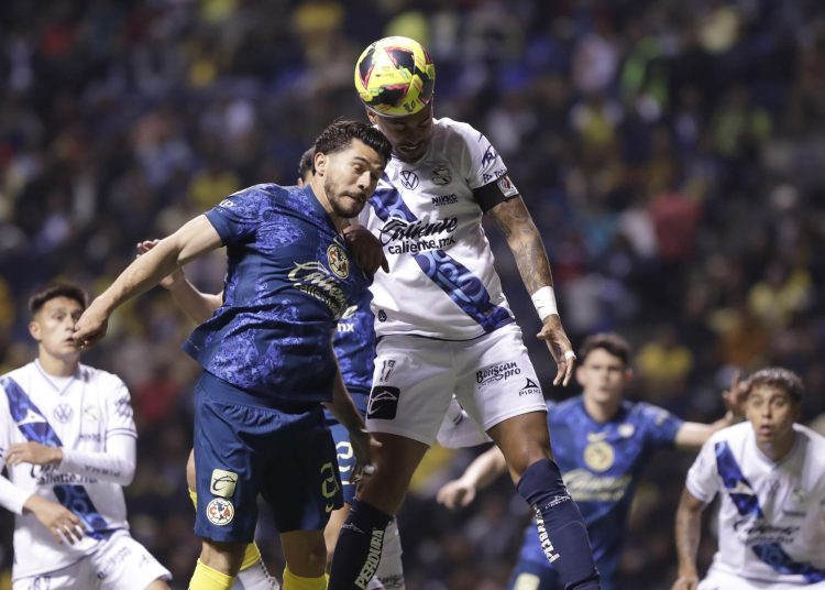MEX2433. PUEBLA (MÉXICO), 07/02/2025.- Emanuel Gularte (d) de Puebla disputa un balón con Henry Martín de América este viernes, durante un partido de la jornada 6 del torneo Clausura 2025 de la Liga MX entre Puebla y América en el estadio Cuauhtémoc, en Puebla (México). EFE/ Hilda Ríos