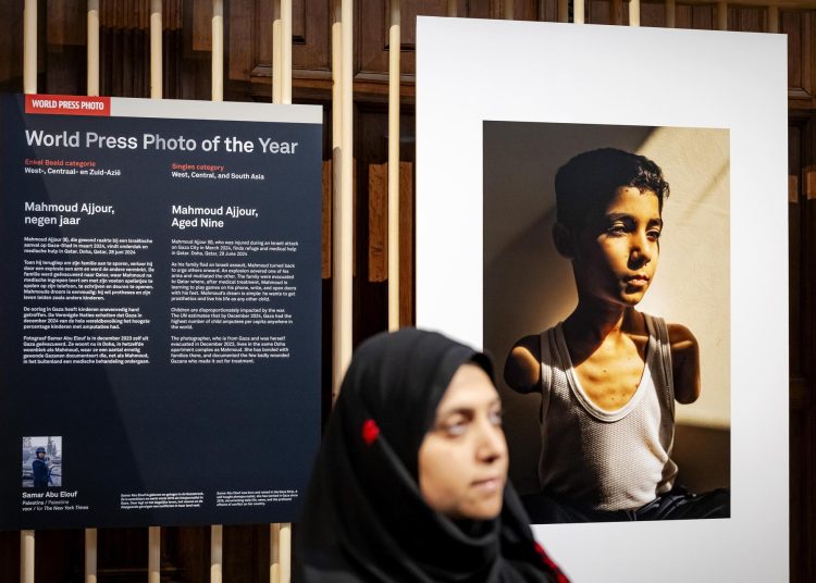 AMSTERDAM (Netherlands), 17/04/2025.- Palestinian photographer Samar Abu Elouf poses before her World Press Photo of the Year winning photograph, during the announcement of the World Press Photo winners at the Nieuwe Kerk in Amstedam, Netherlands, 17 April 2025. Presented every year, the World Press Photo is one of the most prestigious awards for photojournalists (Países Bajos; Holanda) EFE/EPA/ROBIN VAN LONKHUIJSEN