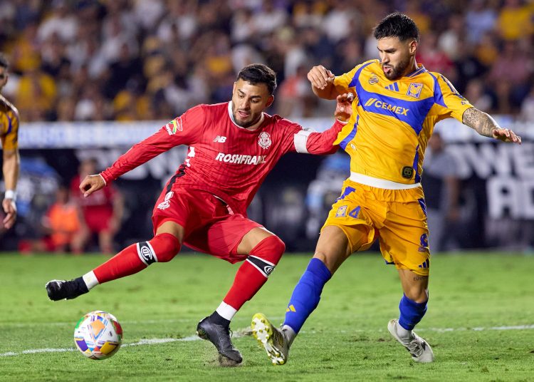 Alexis Vega of Toluca fights for the ball with Juan Sanchez Purata  (R) of Tigres  during the Semi-Final first leg match between Tigres UANL and Toluca  as part of the Liga BBVA MX, Torneo Clausura 2025 at Universitario Stadium on May 14, 2025 in Monterrey, Nuevo Leon, Mexico.