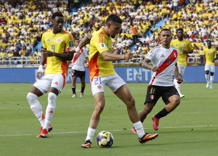 . BARRANQUILLA (COLOMBIA), 06/06/2025.- Daniel Muñoz (c) de Colombia disputa el balón con Bryan Reyna (d) de Perú este viernes, en un partido por las eliminatorias sudamericanas para el Mundial 2026 entre las selecciones de Colombia y Perú en el estadio Metropolitano en Barranquilla (Colombia). EFE/Mauricio Dueñas Castañeda